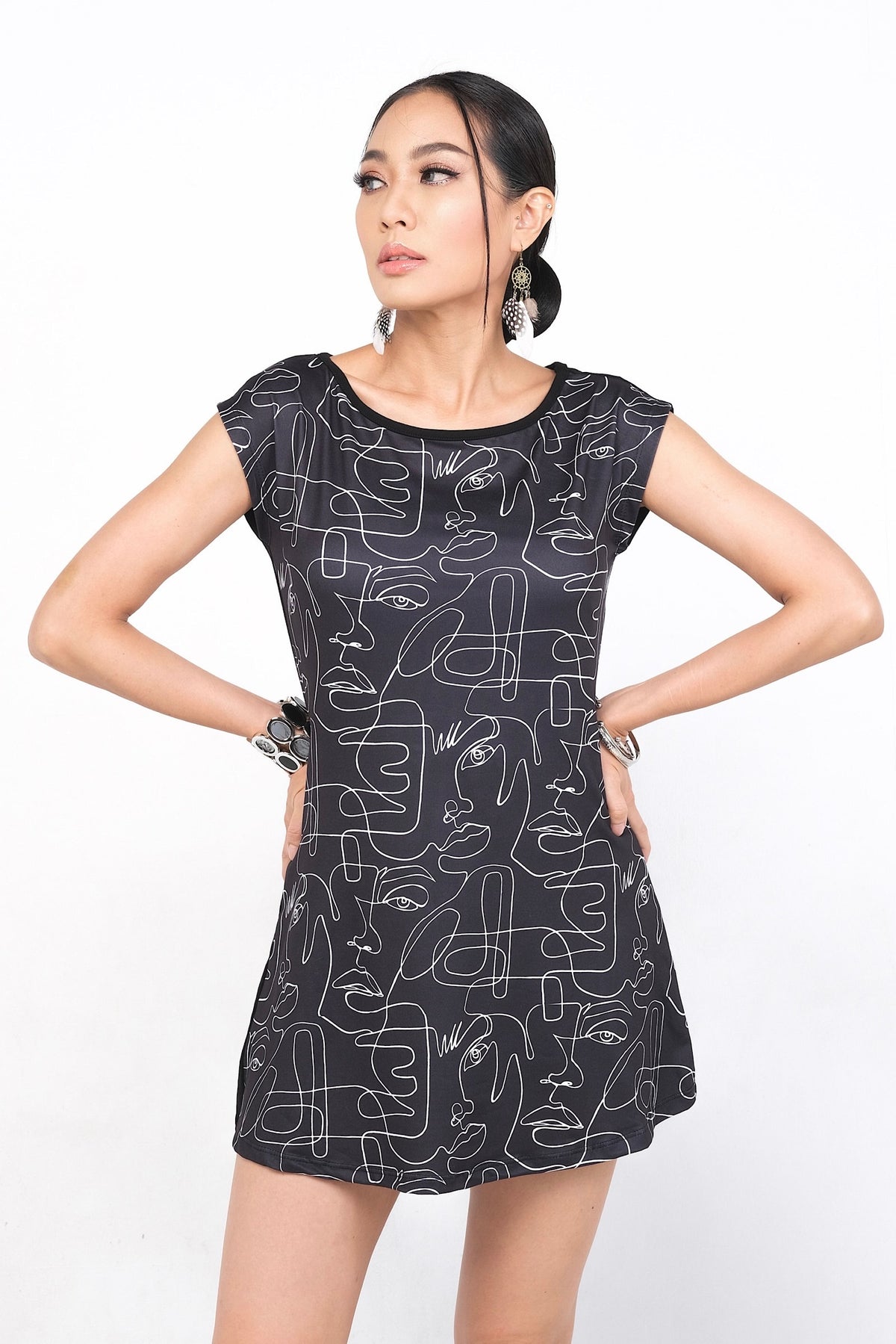 Tunique Emelyne en polyester et spandex, ornée d'un design unique de visages en lignes sur fond marine. Cette pièce est versatile et peut être stylée avec des talons ou des sandales, offrant une coupe flatteuse pour toutes les silhouettes.