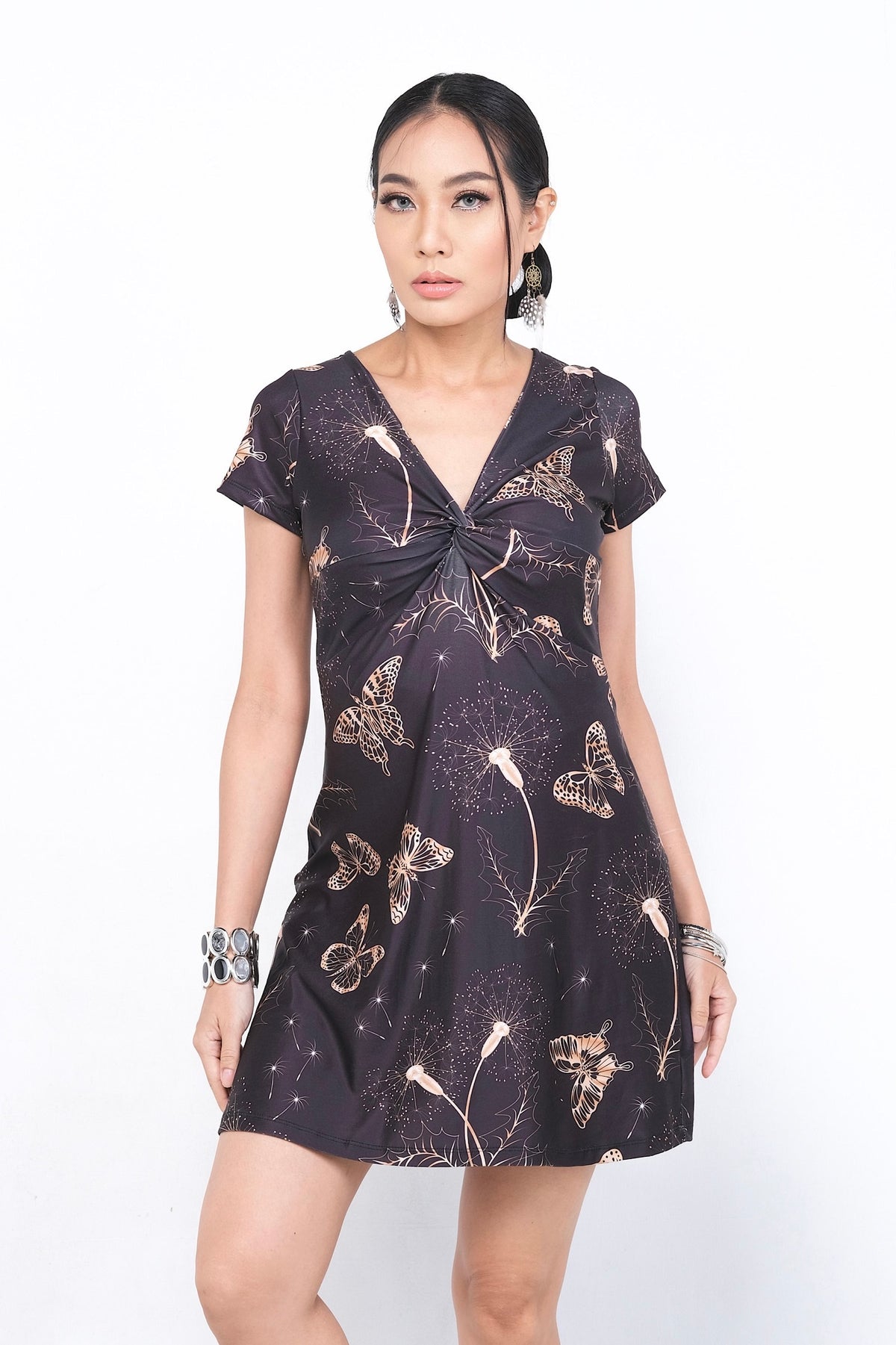 Robe Nolana en polyester et spandex, avec un motif délicat de papillons et de plantes sur fond noir, idéale pour une tenue printanière ou estivale élégante. Disponible sur Trop Belle Pour Toi.
