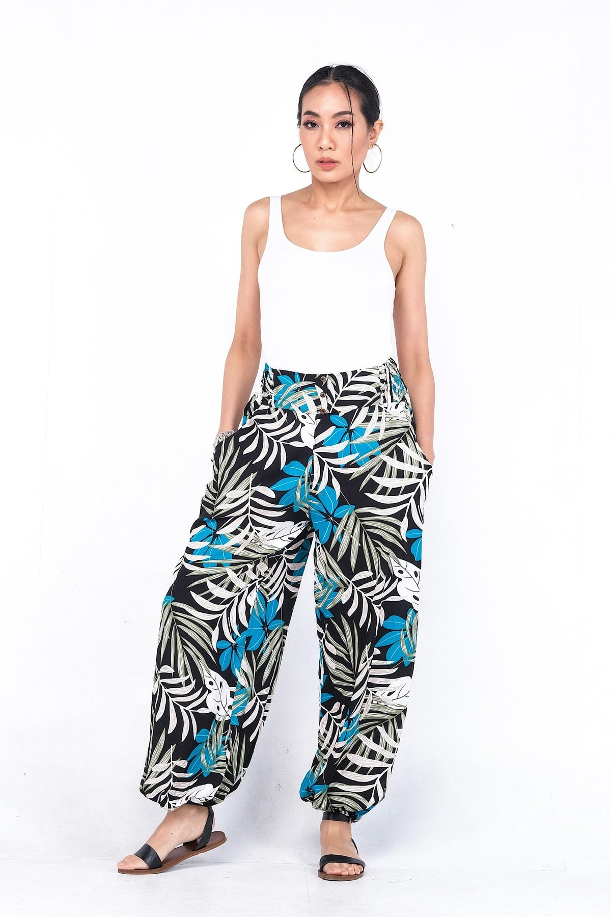 Pantalon en viscose légère, doté d'une ceinture élastique ornée de trois boutons. Idéal pour un confort estival avec ses chevilles élastiques.