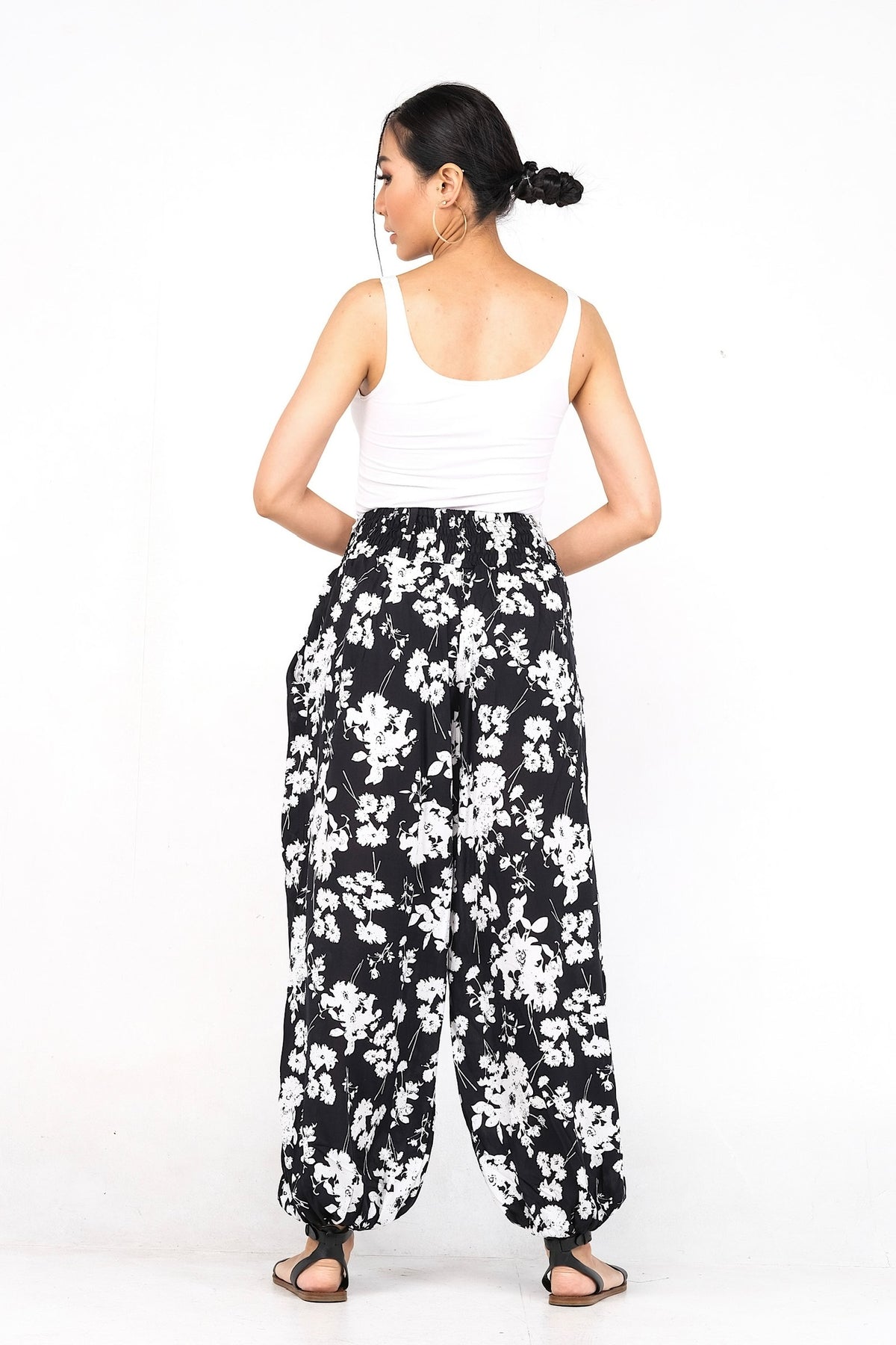 Pantalon en viscose légère, doté d'une ceinture élastique ornée de trois boutons. Idéal pour un confort estival avec ses chevilles élastiques.