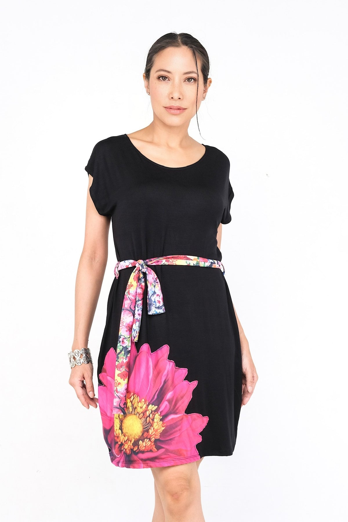 Robe noire avec motif floral rose vif et ceinture assortie.