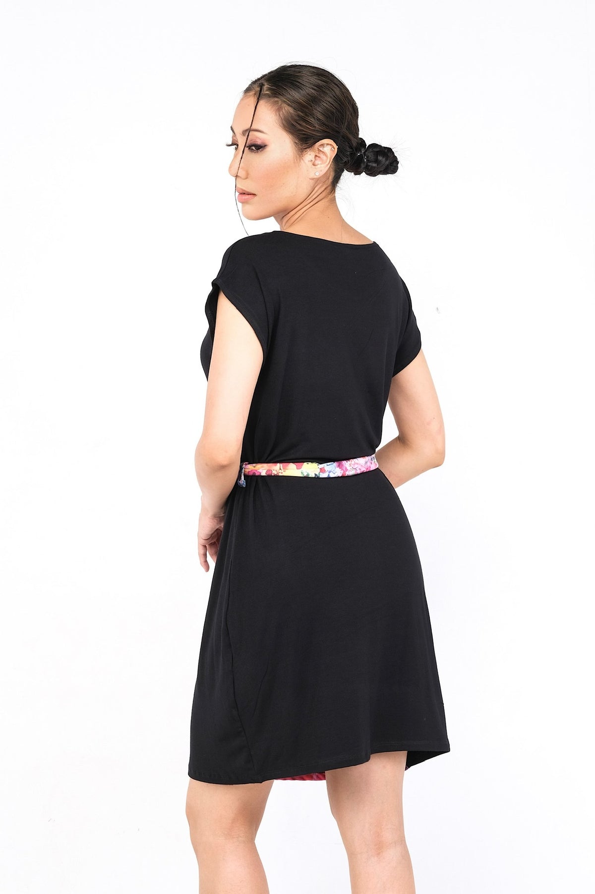 Robe noire avec motif floral rose vif et ceinture assortie.