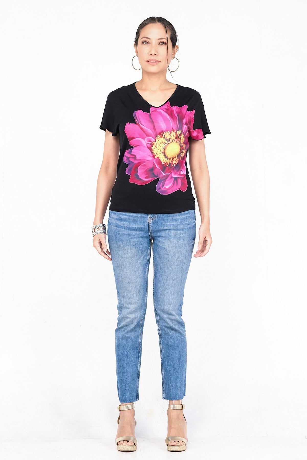 Haut noir avec grand motif floral rose vif.