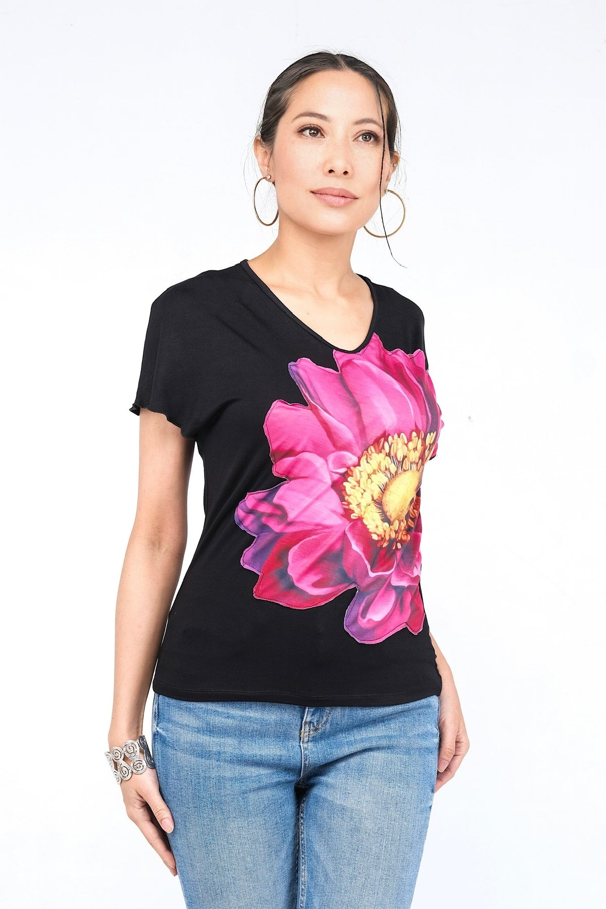 Haut noir avec grand motif floral rose vif.