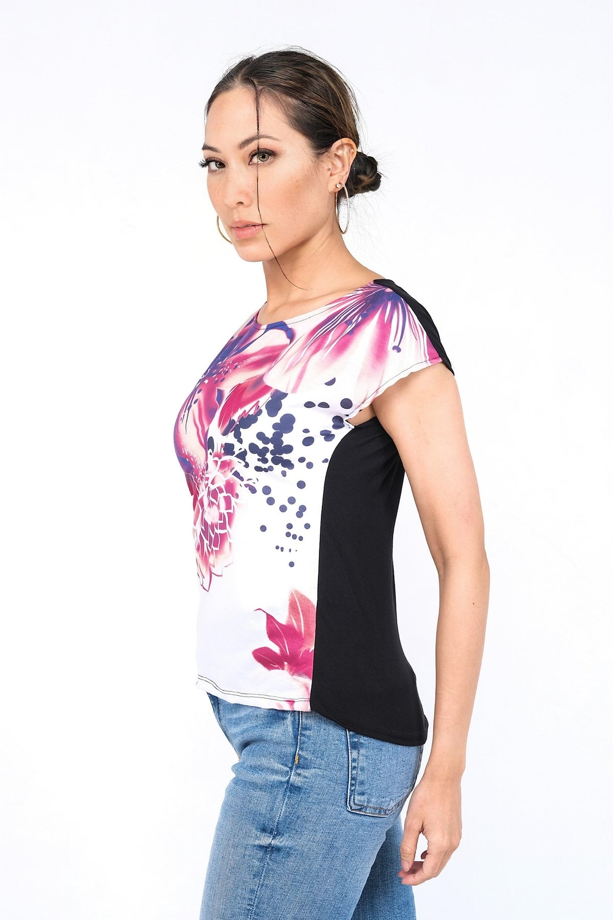 Haut à manches courtes avec motifs floraux roses et violets sur fond blanc. Élégant et confortable.
